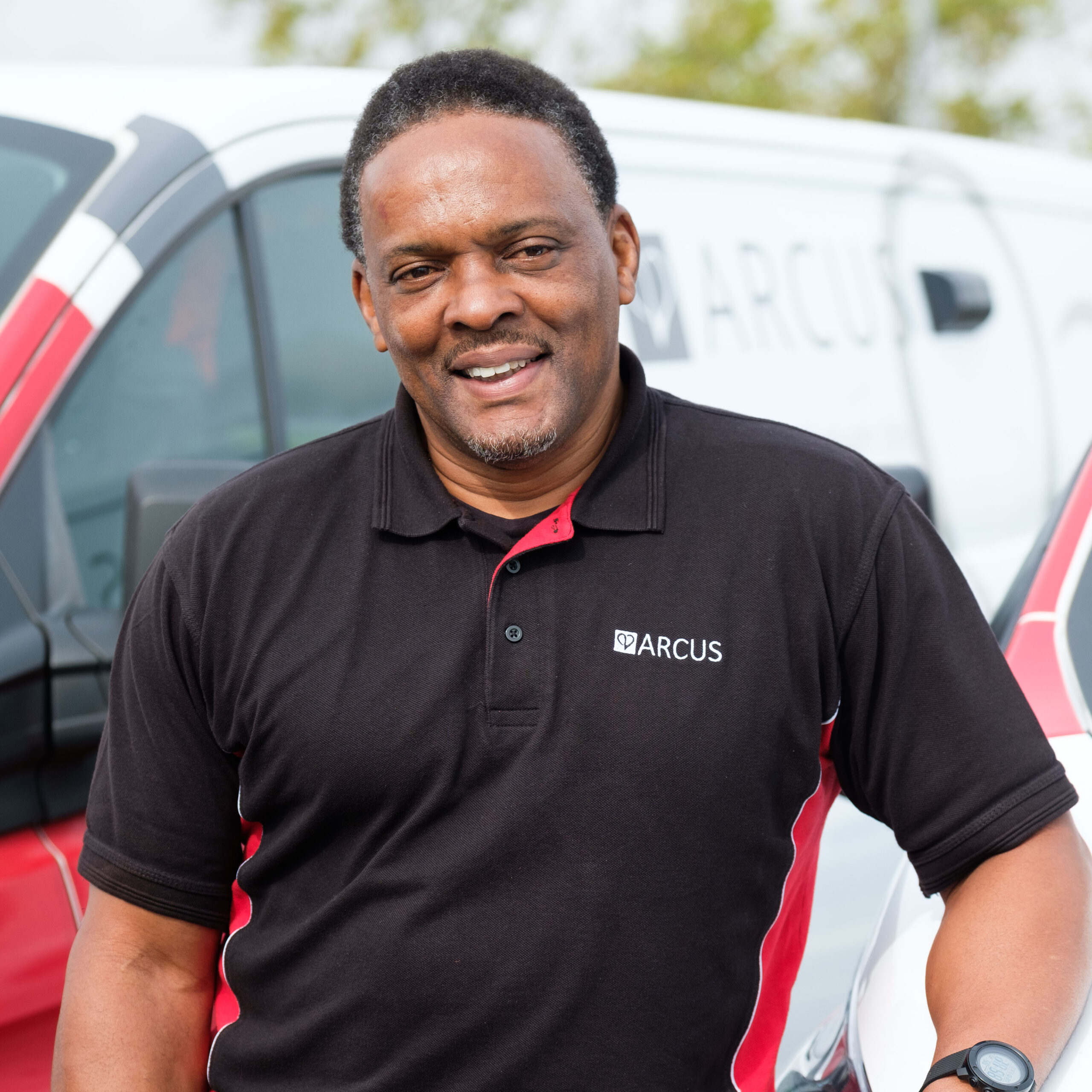 Arcus engineer smiling beside company van